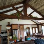 Interior of a custom home with brown stained wood ceiling beams and wood accents on the ceiling