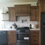 New kitchen remodel with a new gray oven and brown cabinets.