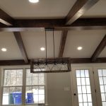 Remodeled home ceiling with exposed beams and a rustic 4-light pendant lighting.