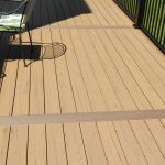 Close up of new, maintenance free decking in tan with black railings.