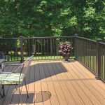 New tan deck with black railings and a black metal outdoor dining set.