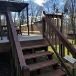 Close up of stairs stained brown on an old wood deck.