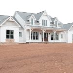 Front exterior of a home with white siding, gray asphalt roofing, brick veneer, decorative shakes, a covered front porch, and brown double doors.